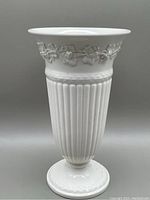 Front view of the cream-colored Wedgwood Queensware vase showing its fluted body and round base.