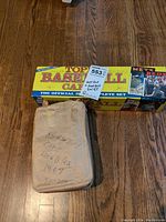 Box showing Topps 1986 Baseball Cards complete set and wrapped bundle of football cards.