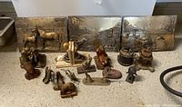 Front view of all items including horse relief panels, bookends and small figurines arranged on floor.
