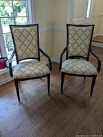 Front view of pair of high back Thomasville captain's chairs with patterned upholstery and dark wood frames.