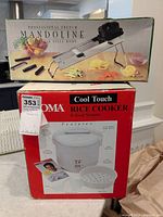 Photo showing Aroma rice cooker box stacked under DeBuyer mandoline slicer box.