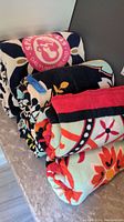 Full view of six rolled Spartina beach towels showing various colorful floral and geometric patterns including the recognizable Spartina 449 pink logo on navy background.