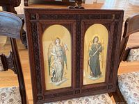 Full view of the two-panel framed artwork on a hardwood floor