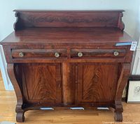 Front view of solid wood antique buffet with two drawers and two locked cabinet doors.