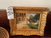 Front view of complete painting in ornate gilt frame with lot tag