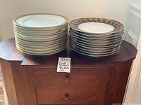 Two stacks of plates on an end table, showing both sets side by side