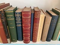Shelf of history books including The Story of France, History of Wattsfield, Private Palaces of London, and others