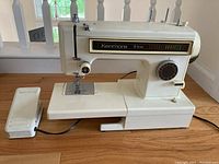Side view of vintage off-white Kenmore 8 stitch sewing machine with foot pedal showing model and stitch indicator