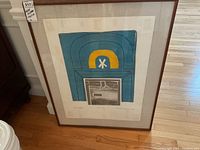 Full frontal view of framed print leaning against wall on hardwood floor.