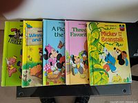 Photo showing five Disney children's books: Three Little Pigs, Winnie the Pooh and Tigger Too, A Picnic with Mickey, Three Favorite Tales, Mickey and the Beanstalk.