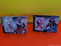 Photo showing two NFL cards with fabric ribbon patches worn by the players, Jamaal Charles and Arian Foster.