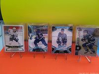 Four Auston Matthews hockey cards each in clear protective sleeves shown front side