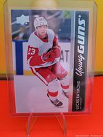 Photo of Lucas Raymond Young Guns Rookie Card in protective sleeve on display stand.