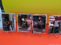Four Max Verstappen trading cards in stands, each showing the driver in Red Bull racing gear in different poses, one with a flag background.