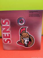 Front cover of the packaging showing Ottawa Senators logo and a $1 coin.