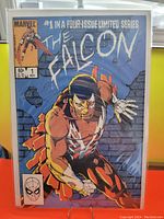 Front cover of The Falcon #1 comic book showing superhero bursting through a wall with Marvel branding and issue details.