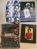 Top view of Bruno Mars promotional items including concert pass, T-shirt, Bob Dylan concert booklet with ticket, and Bruno Mars Live at The Apollo booklet