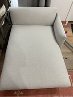 Top view of light beige lounge sofa with right side armrest showing seat and backrest.