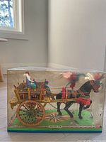 Front side view of the Mexican handmade wooden horse carousel figurine inside a clear plastic display case.