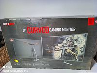 Sealed retail box front showing Deco Gear branding and 39" Curved Gaming Monitor text with soldier shooter hero image