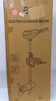 Side view of cardboard packaging showing printed sketch of electric outboard motor and text 'Electric Outboard Motor'.