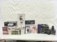 Full view showing all boxed items: LED downlight set, ceiling fan, outdoor wall lamp, security door viewer, wireless camera system, smart lock deadbolt, and ceiling fan remote control.