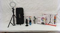 Overview of influencer starter kit including two ring lights on stands, microphone, Bluetooth remote, and carrying bag.