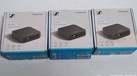Three boxed Sennheiser Bluetooth Audio Transmitters in original packaging, front view showing device image and branding.