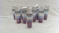 Ten brand new Ello tumblers, sealed in plastic, arranged standing upright showing their full height and gradient color