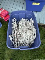 Blue plastic storage bin containing multiple bundled strings of white Christmas lights.