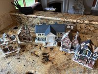 Five ceramic Christmas village houses on granite countertop, unlit.