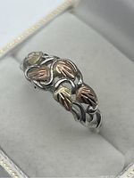 Close-up top view of the sterling silver ring with mixed 10K gold leaf pattern.