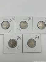 Five Buffalo Nickels, dated 1929 and 1937 visible, worn condition, in individual protective holders.