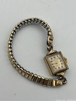 Full view of Birks Rideau 10kt gold filled ladies' watch with expandable band laid flat.