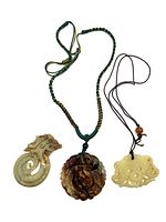 Overview of the three Chinese stone-carved pendants with different dragon and bat designs.