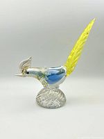 Side view of colorful Murano glass pheasant on clear twisted base showing detailed head, blue body and yellow tail feather.