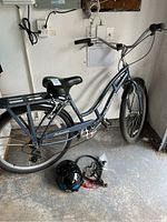 Full side view of blue Schwinn road bike with helmet, bell, and lock on ground.