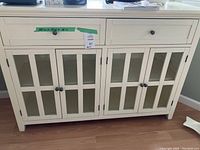 Front view of cabinet showing two drawers and four glass-paneled doors