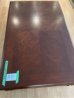 Top view of wooden coffee table showing wood grain pattern and measurements taped to side.