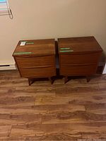 Front view of both teak nightstands side by side on wood floor
