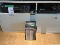 Samsung VHS player and LG Blu-ray player stacked inside a white TV stand, with the complete Columbo DVD series placed in front on the floor.