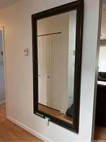 Full view of the large rectangular wall mirror hung on a wall showing its size relative to the room.