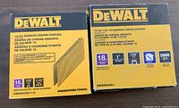 Two yellow DeWalt boxes with labels showing 18 gauge narrow crown staples, one with 1 inch staples, the other 1.5 inch staples, both partially full