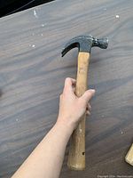 First hammer showing the claw head and wooden handle with paint marks.