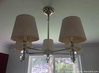 Light fixture installed and hanging with three lampshades.
