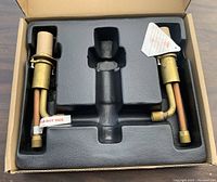 Top view of new plumbing hot and cold water distribution fixture with labels and protective foam packaging.