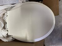 Top closed view of the white soft closing toilet seat showing smooth, glossy finish and oval shape.