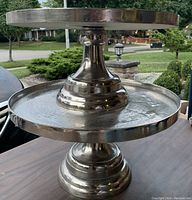 Image showing two metal pedestal trays stacked with the top view and base visible