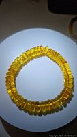 Front view of the stretchy bracelet showing chunky polished golden amber beads under bright light.