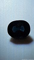 Close up view of spinel gemstone revealing deep blue color and internal characteristics.